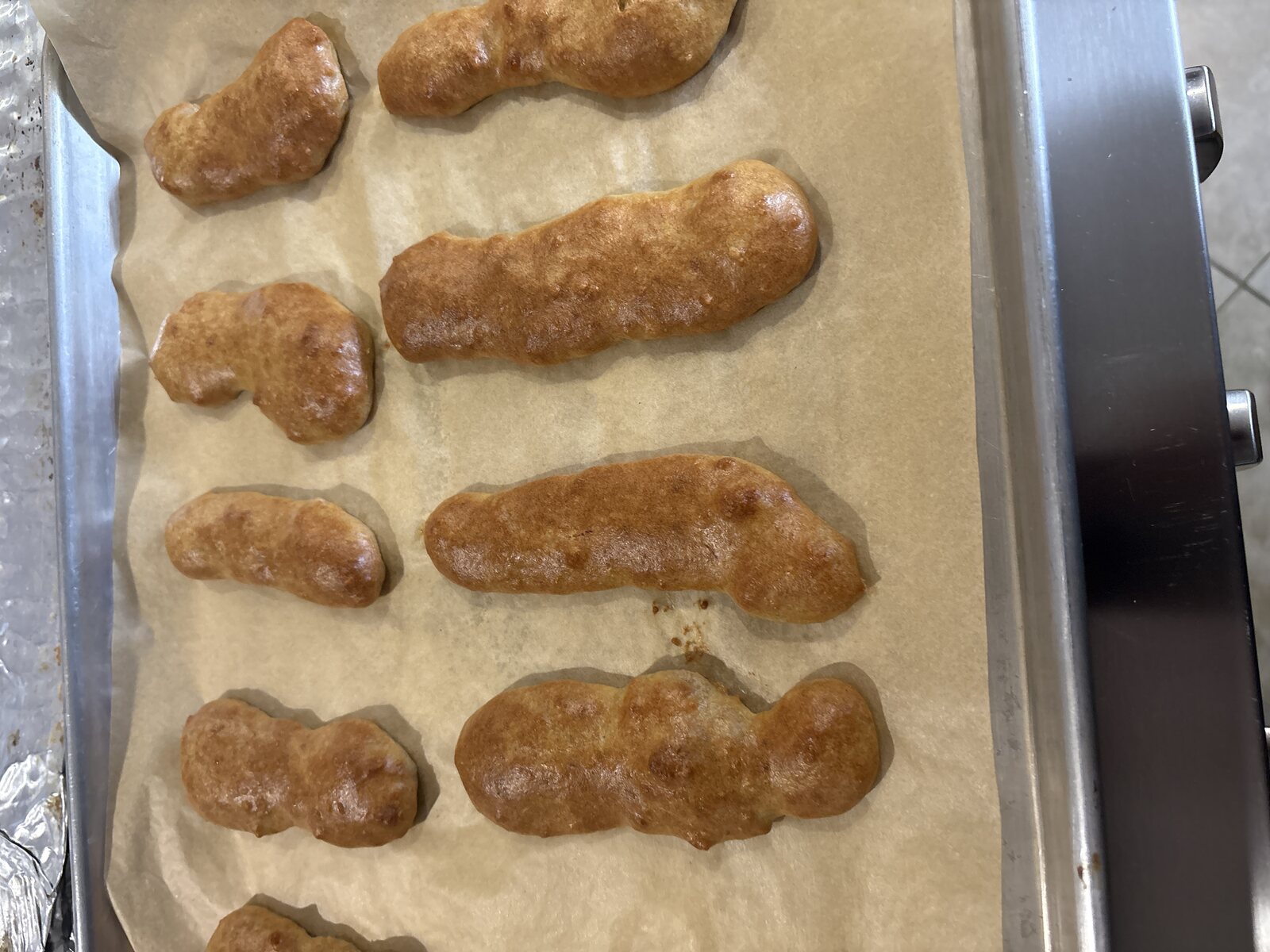 A tray of the baked eclair shells, cooling on parchment paper